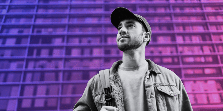 young man in a baseball cap looking up on a purple and pink gradient background