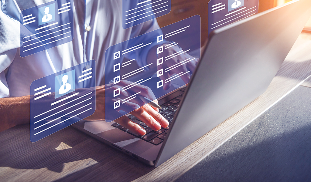 hands typing on laptop with floating screen images, depicting an AI virtual interview