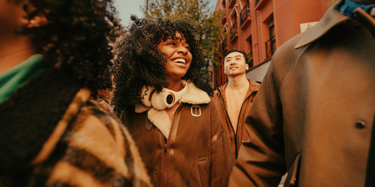 Young woman smiling and walking, surrounded by good friends