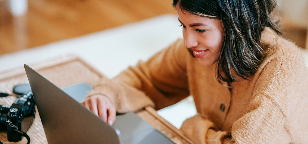 Young woman keeping track of her experiences on a laptop computer