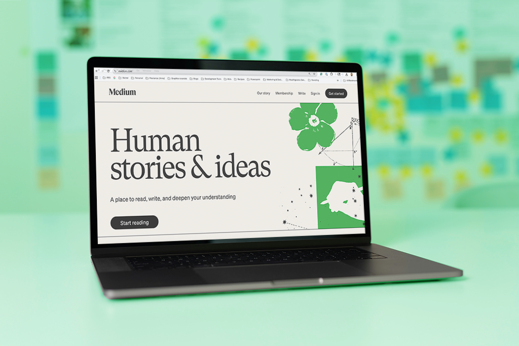 A laptop computer with the Medium homepage against a green background