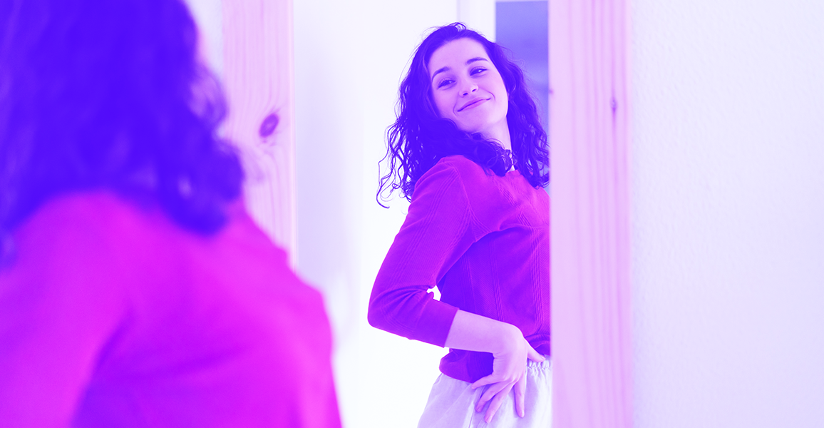 Young woman, smiling confidently at reflection