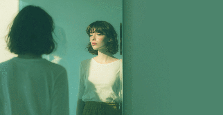 sad young woman, looking in the mirror