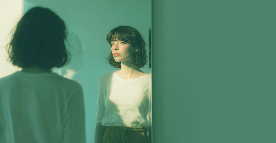 sad young woman, looking in the mirror