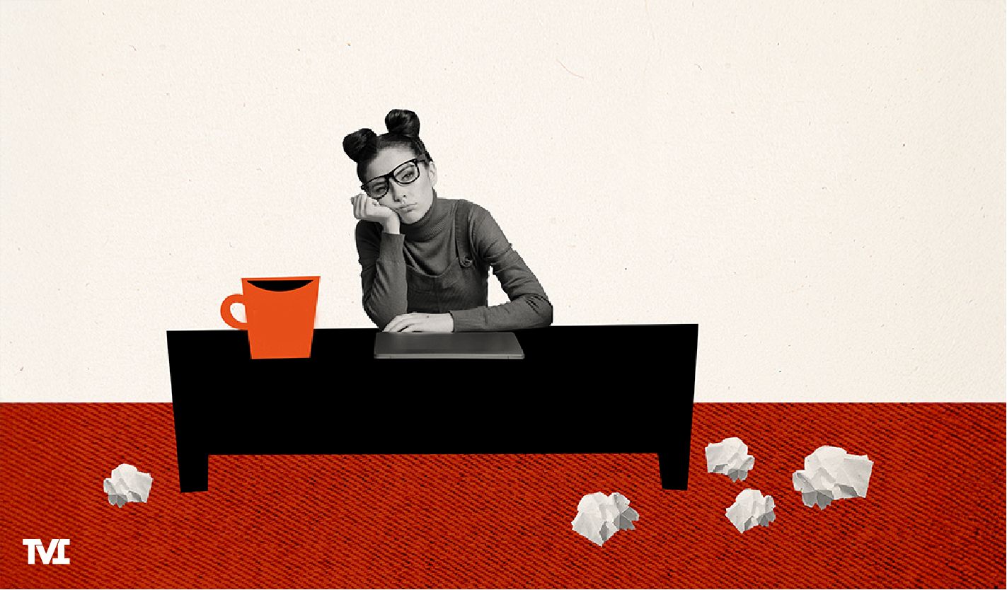 a young woman sitting behind a desk, looking bored and unengaged