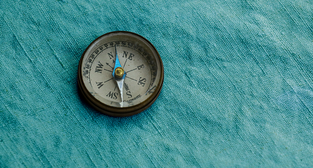 An old compass on teal canvas